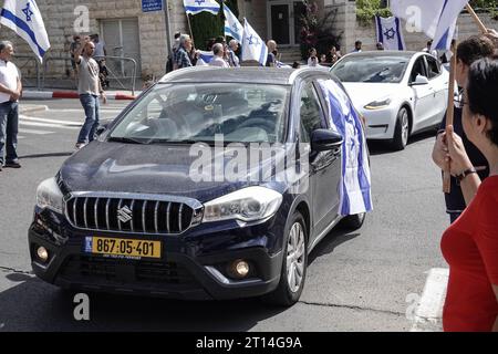 Jerusalem, Israel. Oktober 2023. Trauerprozession für IDF Golani Brigade Sgt Adi Tzur verlässt das Haus der Familie, während Hunderte mit israelischen Fahnen die Straße säumen, um ihren Respekt und Dankbarkeit für sein Opfer zu zollen. Tzur war unter Hunderten, die nach dem massiven Raketenfeuer aus dem Gazastreifen auf Israel am 7. Oktober 2023, der Infiltration von bewaffneten Männern auf israelisches Territorium, dem Massaker an Frauen und Kindern in ihren Häusern und der Geiselnahme von Zivilisten und Soldaten nicht mehr bekannt waren. Israel ist in einen Krieg mit der Hamas im Gazastreifen verwickelt. 300.000 Reservisten und die IS wurden eingesetzt Stockfoto