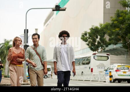 Gruppe erwachsener Freunde, die an sonnigem Tag in der Stadt spazieren gehen Stockfoto