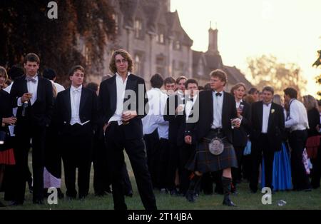 Wohlhabende Studenten der 1990er Jahre in Großbritannien, am Morgen nach der Nacht davor. Studenten und Freunde in formeller schwarzer Krawatte, die sich auf den College-Rasen stürzen, nach einer Nacht voller Feiern, ist der Mai-Ball Ende des Jahres. Die Royal Agricultural University hieß früher Cirencester Royal Agricultural College. Cirencester Gloucestershire, England, Mai 1995 HOMER SYKES. Stockfoto