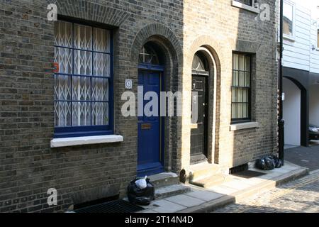 Eine Fassade eines modernen Gebäudes mit einer hellblauen Tür und großen Fenstern in London, Großbritannien. Stockfoto