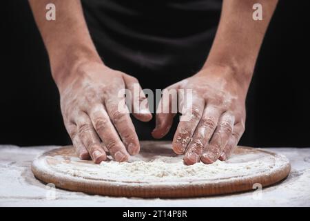 Bäcker Hände kneten Teig in Mehl. Der Bäcker bereitet vor, Essen zubereiten, Nahaufnahme Stockfoto