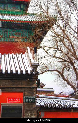 Erkunden Sie das bezaubernde Spektakel der vielfarbigen traditionellen Häuser, eingebettet in ein winterliches Wunderland unter einer unberührten chinesischen Schneelandschaft Stockfoto