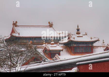 Erkunden Sie das bezaubernde Spektakel der vielfarbigen traditionellen Häuser, eingebettet in ein winterliches Wunderland unter einer unberührten chinesischen Schneelandschaft Stockfoto