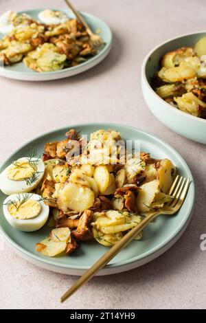 Köstliche herzhafte Abendessen oder Mittagessen, gebratene junge Kartoffeln mit Waldpilzen Chanterelles mit Dill, gekochte Eier, saisonale Speisen Stockfoto
