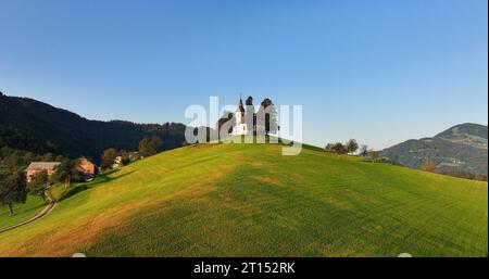 St. Thomas-Kirche in Skofja Loka, Slowenien, aus der Vogelperspektive bei Sonnenaufgang goldene Stunde Stockfoto