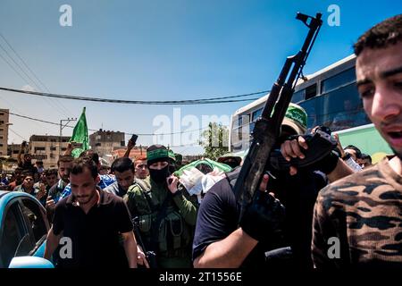 Michael Bunel / Le Pictorium - Konflikt in Gaza - 15/05/2018 - Palästina / Gazastreifen / Gaza - Amr Abu-Fouls Leiche wird von Mitgliedern des bewaffneten Flügels der Hamas (Al-Quassam) auf die Straße getragen. Die Familie bringt sie dann zum östlichen Friedhof, der mehrere Kilometer entfernt ist. Er starb heute Morgen an einer Brustwunde nach Scharfschützenfeuer während der gestrigen Auseinandersetzungen an der Grenze zwischen Gaza und Israel in Malaka. Mai 2018. Gazastreifen. Palästina. Stockfoto