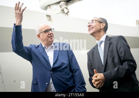 Bremen, Deutschland. Oktober 2023. Andreas Bovenschulte (SPD, l), Bürgermeister von Bremen, und Pierre Godart, deutscher Chef der Ariane-Gruppe, stehen im Hafen von Neustadt auf dem Schiff „Canopee“, das speziell für den Transport der neuen europäischen Trägerrakete Ariane 6 entwickelt wurde. Der Segelfrachter hat erstmals in Bremen angedockt und soll bis Ende des Jahres erstmals Teile der Rakete von Europa zum europäischen Raumflughafen Kourou in Französisch-Guayana transportieren. (An dpa 'Fraghter for Ariane 6 Rocket to Transport Parts') Credit: Sina Schuldt/dpa/Alamy Live News Stockfoto