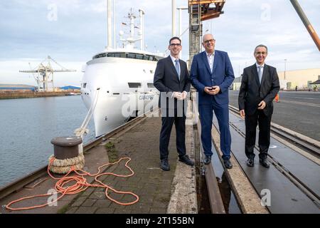 11. Oktober 2023, Bremen: Matthias Magnor (l-r), Mitglied des Vorstands der BLG Logistics, Andreas Bovenschulte (SPD), Bürgermeister von Bremen, und Pierre Godart, Leiter der Ariane-Gruppe Deutschland, stehen vor dem Schiff „Canopee“, das speziell für den Transport der neuen europäischen Trägerrakete Ariane 6 im Hafen von Neustadt konzipiert wurde. Der Segelfrachter hat erstmals in Bremen angedockt und soll bis Ende des Jahres erstmals Teile der Rakete von Europa zum europäischen Raumflughafen Kourou in Französisch-Guayana transportieren. (Zum dpa-Frachter für Ariane-6-Rakete Stockfoto