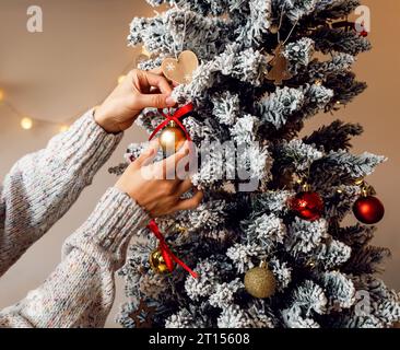 Weihnachtsbaumschmuck in Frauenhänden. Den Weihnachtsbaum schmücken. Stockfoto