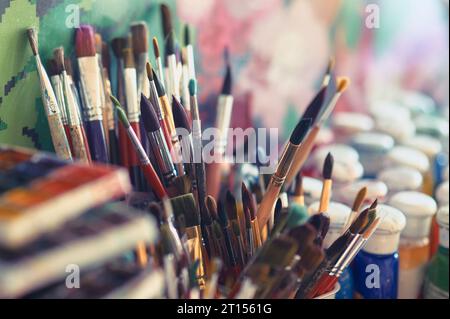 Pinsel und Aquarellfarben auf dem Tisch in einer Werkstatt, selektiver Fokus, Nahaufnahme Stockfoto