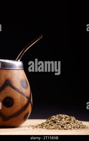 Traditioneller südamerikanischer Yerba Mate Tee im Calabash Circle und Bombilla. Schwarzer Hintergrund. Nahaufnahme. Stockfoto