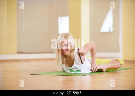 Die wunderschöne, sportlich geschnittene Yogi-Frau übt Yoga Asana Bhekasana - Froschhaltung in der Yoga-Klasse Stockfoto