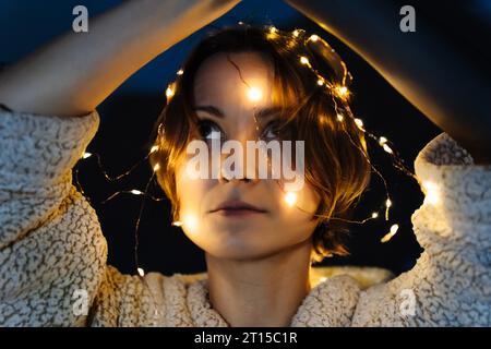 Porträt einer kurzhaarigen Frau mit Lichtern auf dem Kopf Stockfoto