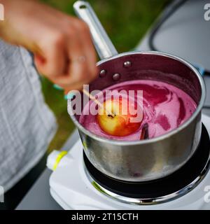 Glasierte Äpfel in einem Eisentopf kochen. Stockfoto