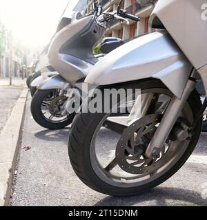 Geparkte Motorroller auf einer Straße im beliebten Ferienort Riva del Garda in Italien Stockfoto