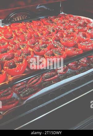 Sonnengetrocknete Tomaten mit provenzalischen Kräutern. Tomaten werden im Ofen getrocknet Stockfoto