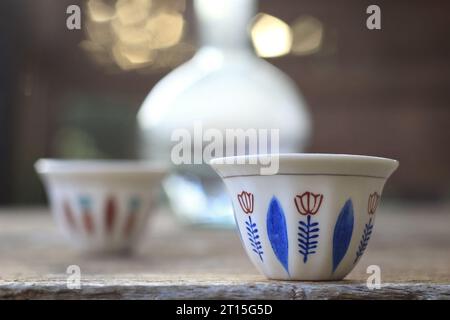 Zwei traditionelle libanesische Kaffeetassen zusammen mit einer Wasserkanne aus Glas und Ebenrik. Stockfoto