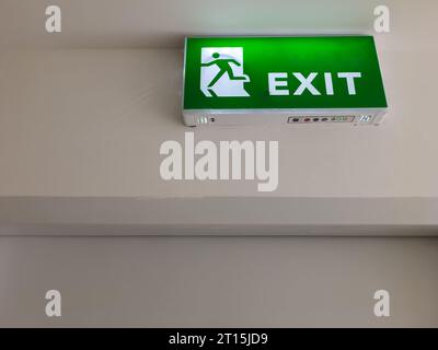 Das grüne Notausgangssymbol an der Decke zeigt Fluchtwege außerhalb des Gebäudes, wenn das Feuer, Vorderansicht mit dem Kopierraum. Stockfoto