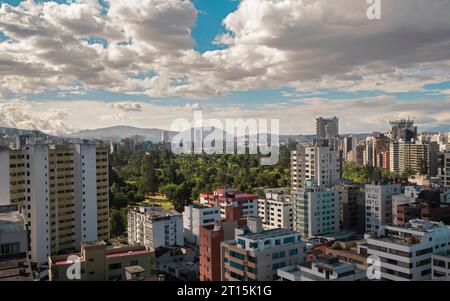 Panoramablick auf den nördlichen zentralen Bereich der Stadt Quito mit La Carolina Park im Zentrum bei einem bewölkten Sonnenuntergang. Ecuador Stockfoto