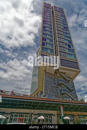 Der verglaste Turm des Standard Hotels überspannt den High Line Park auf massiven Betonpfählen in der West 13th Street. Stockfoto