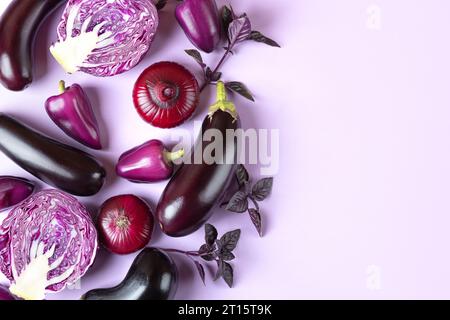 Zusammensetzung von frischen Gemüse Auberginen, Kohl, Pfeffer, Zwiebeln und Basilikumblättern auf pastelllilavendelfarbenem Hintergrund. Kreatives Lebensmittelkonzept. Flach Stockfoto