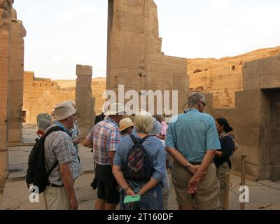 Besuchen Sie die Stätten des antiken Ägypten auf einer Nilkreuzfahrt: Touristen stehen vor den Säulen und hören, wie ihr Reiseleiter über den KOM Ombo Tempel spricht. Stockfoto