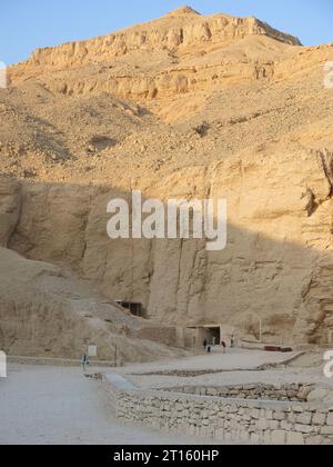 Das Tal der Könige des alten Ägyptens: Blick auf den goldenen Kalkstein und die Klippen und einen Grabeingang an einem hellen, heißen Tag im Oktober 2023. Stockfoto