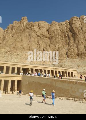 Touristen strömen, um den herrlichen Grabentempel der Hatschepsut zu sehen, der in die Klippen gebaut wurde, ein Meisterwerk der Architektur im alten Ägypten. Stockfoto