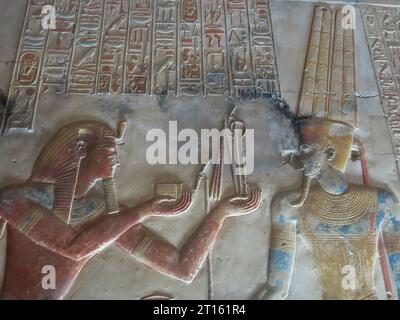 Farbenfrohe, geschnitzte Reliefs in der Osiris-Kapelle am Großen Tempel von Seti I. in Abydos, einer der ältesten Städte des alten Ägypten. Stockfoto