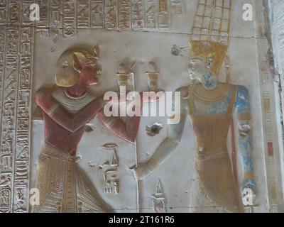 Farbenfrohe, geschnitzte Reliefs in der Osiris-Kapelle am Großen Tempel von Seti I. in Abydos, einer der ältesten Städte des alten Ägypten. Stockfoto