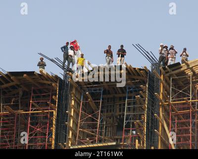 Blick auf die Arbeiter auf einem massiven Gebäude, das Teil der neuen Straßenbrücke ist, die über den Nil bei Manfalut gebaut wird. Stockfoto