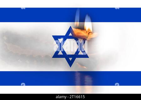 Brennende Kerzen und hölzerne Rosenkranzbäume auf dem Tisch vor dem Hintergrund der israelischen Flagge, der Krieg in Israel und die Trauer um die Menschen, die in der getötet wurden Stockfoto