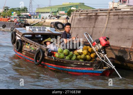 Fong Dien schwimmende Marktszene, in der Nähe von Can Tho, Vietnam. Der Anbieter von Frühstücksartikeln zirkuliert unter größeren Booten, die Produkte transportieren. Stockfoto