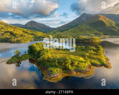 Aus der Vogelperspektive auf die Insel Eilean Munde, dahinter das Dorf Ballachulish mit dem Hafen und dem ehemaligen Schieferbruch im westlichen Teil von Stockfoto