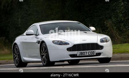 Bicester, Oxon., UK - 8. Oktober 2023: 2011 weißer Aston Martin V8 Vantage Oldtimer auf einer englischen Landstraße. Stockfoto