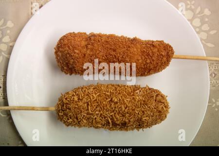 Heiße Cheetos und Ramen Maishund auf einem Teller Stockfoto