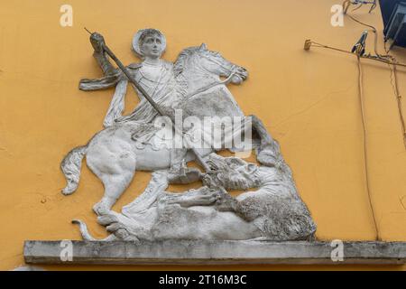 Nahaufnahme eines Basreliefs mit dem Heiligen Georg und dem Drachen an der Außenseite eines Gebäudes in Parma, Emilia-Romagna, Italien Stockfoto