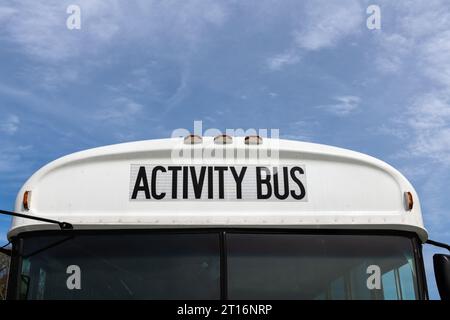Nahaufnahme eines Aktivitätsbusses oder einer Schulaktivität mit Lichtern und blauem Himmel. Stockfoto