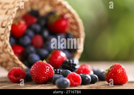 Verschiedene frisch reife Beeren auf Holztisch draußen, Nahaufnahme Stockfoto