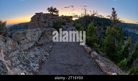 Der asphaltierte Weg zwischen Bright Angel Point und dem Besucherzentrum am Grand Canyon North Rim Arizona in der Dämmerung. Stockfoto