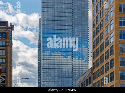 Sky ist ein 71-stöckiger Wohnhochhaus an der West 46th Street in Hell’s Kitchen (Clinton); die Spiegelglasfassade reflektiert den Himmel. Stockfoto