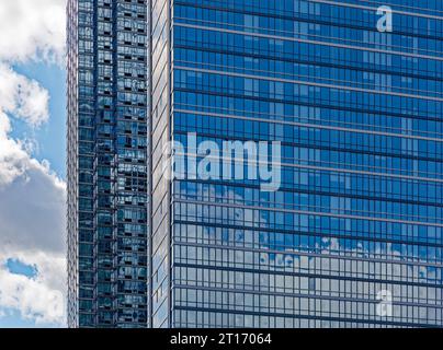 Sky ist ein 71-stöckiger Wohnhochhaus an der West 46th Street in Hell’s Kitchen (Clinton); die Spiegelglasfassade reflektiert den Himmel. Stockfoto