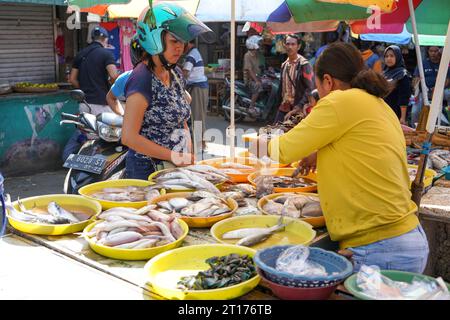 Lage auf dem traditionellen Fischmarkt. Fischverkäufer handeln mit potenziellen Käufern über Preise. Ein Fischmarkt ist ein Fischmarkt. Stockfoto