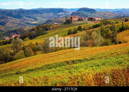 Blick auf die wunderschönen Hügel mit herbstlichen Weinbergen in der Nähe von Barolo im Piemont, Italien. Stockfoto