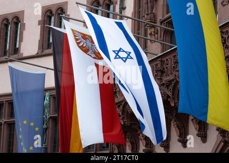 Solidarität mit Israel und der Ukraine am Balkon des Römers in Frankfurt am Main sind zusätzlich zur Europa- und Deutschland-Fahne rechts sowie dem Frankfurter Stadtwappen Mitte aus Solidarität die Nationalflaggen Israels und der Ukraine rechts gehisst. Am 24. Im Februar 2022 begann die Invasion russischer Truppen in die Ukraine. Seitdem dauert der Angriffskrieg Russlands an. Am 07. Oktober 2023 hatte die radikalistische Hamas von Gaza aus überraschend einen Angriff auf Israel begonnen. Frankfurt am Main Römerberg Hessen Deutschland *** Solidarität mit Israel und der Ukraine auf dem Balkon des Hotels Stockfoto