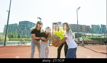 Die Familie spielt Basketball auf dem Platz Stockfoto