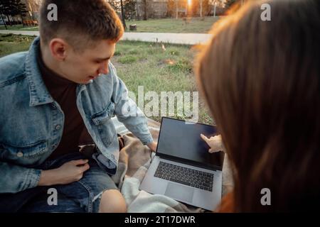 Innovative Vorbereitung: Prüfungsbereitschaft blüht, während die Schüler die Ruhe von Park nutzen Stockfoto