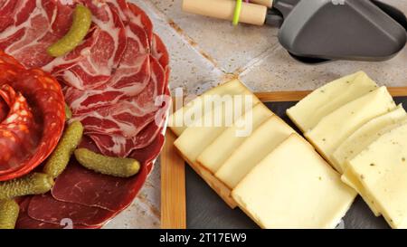 Charcuterie und Raclettekäse Stockfoto