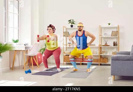 Lustige fette Frau und ihr fitter Sporttrainer, die zu Hause aktives Fitnesstraining machen Stockfoto