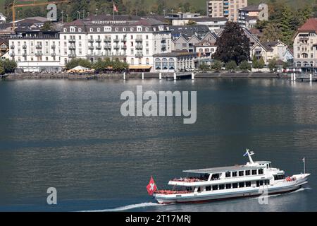 Das Schiff mit dem Namen Brunnen auf dem Vierwaldstättersee bei einer Rundfahrt. Im Hintergrund das Hotel Waldstätterhof in der Ortschaft Brunnen. Das Schiff mit dem Namen Brunnen auf dem Vierwaldstättersee bei einer Rundfahrt. Im Hintergrund das Hotel Waldstätterhof in der Ortschaft Brunnen. Brunnen Kanton Schwyz Schweiz *** das Schiff Brunnen am Vierwaldstättersee bei einer Rundfahrt im Hintergrund das Hotel Waldstätterhof im Dorf Brunnen das Schiff Brunnen am Vierwaldstättersee bei einer Rundfahrt im Hintergrund das Hotel Waldstätterhof im Dorf Brunnen Brunnen Kanton S Stockfoto